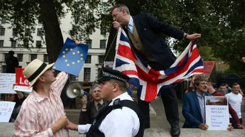 Getty Images A police officer separates Remain and Leave activists in Parliament Square, September 2016