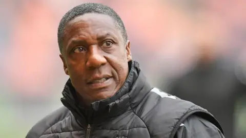 Terry Connor on the touchline during a game looking over his left shoulder