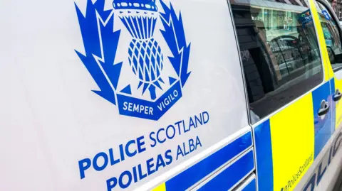 A close-up picture of a police van with the Scottish police logo in blue and yellow