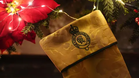 PA Media A close-up of the top of the stocking, which has a black embroidered King's Foundation crest.