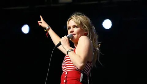 Duffy on stage in a red and white top