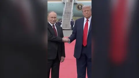 Russian President Vladimir Putin shaking hands with American President Donald Trump in front of Air Force One