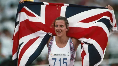 Getty Images Sally Gunnell from Great Britain carries her national flag after winning the women's 400-meter hurdles at the 1992 Olympics.