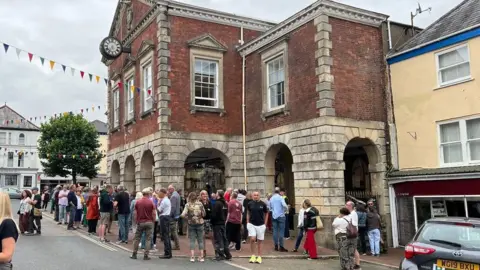 Crowds of people gathering outside Torrington Town Hall