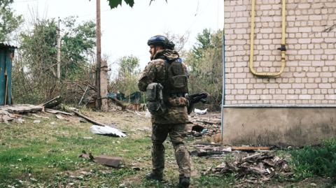 A Ukrainian police officer inspects the area during the evacuation of local people from territories bordering Russia, in the town of Vovchansk, Kharkiv region, north-eastern Ukraine, 13 May 2024