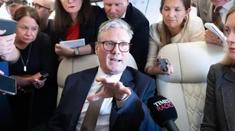 PA Media Prime Minister Sir Keir Starmer talks to journalists as he travels onboard a plane to Washington DC to attend a Nato summit.