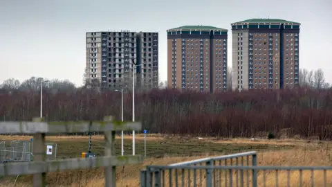 A general view of the Allan, Coursington and Draffen Towers in Motherwell. The three towers are made of light brick and are in the background of the picture.