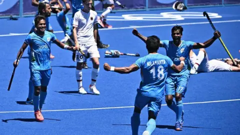 Getty Images Players of India celebrate after winning the men's bronze medal match of the Tokyo 2020 Olympic Games field hockey competition by defeating Germany 5-4, at the Oi Hockey Stadium in Tokyo, on August 5, 2021. (Photo by Anne-Christine POUJOULAT / AFP) (Photo by ANNE-CHRISTINE POUJOULAT/AFP via Getty Images)