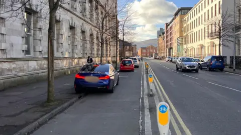 Meghan Hoyt Cars parked inside a cycle lane with cycling bollard on the right