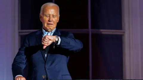 Joe Biden checks his watch during Fourth of July celebrations at the White House