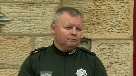 Supt McGowan is wearing a green police t-shirt.