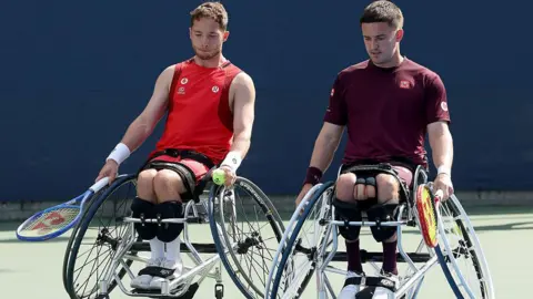 Alfie Hewett and Gordon Reid sit in wheelchairs and hold tennis racquets