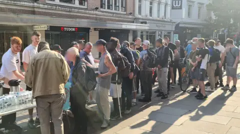 Two Brews Dozens of people queue up for food and drink provided by Two Brews charity in Manchester city centre.