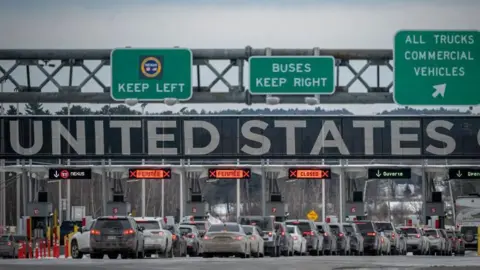 Cars wait in line to enter the United States at a border crossing at the Canada-US border in Blackpool, Quebec, Canada, on 2 February, 2025