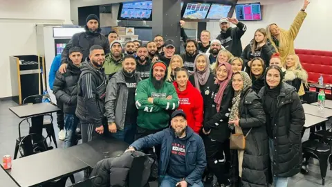 Atiq Rehman A group of volunteers from Unspoken smiling for camera in a restaurant