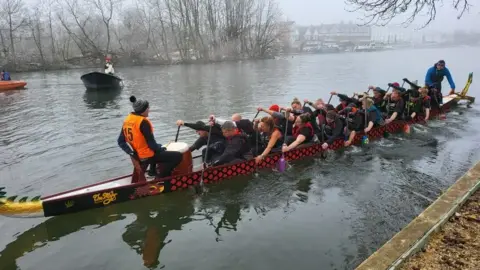 The Soaring Dragons boat club on a dragon boat on a river