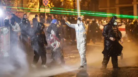 EPA protesters wearing rain jackets and hoods were doused with water, as one of them shouted insults at the police.