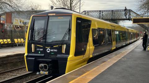 A new electric Merseyrail train at a station 