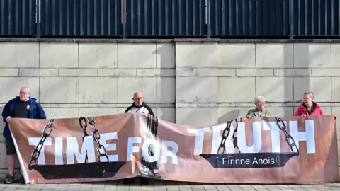 PACEMAKER Four people holding a brown banner with 'Time for Truth' written on it in white writing.