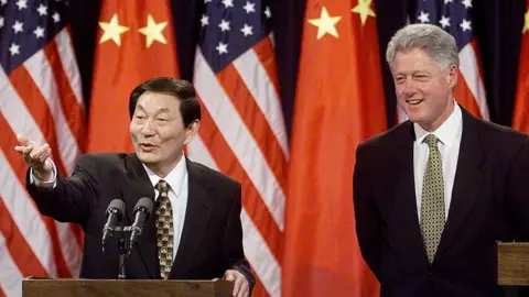 AFP via Getty Images Chinese Premier Zhu Rongji (L) answers reporters' questions at a joint press conference with US President Bill Clinton