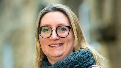 Ely Cathedral Alison Binstead with long blond hair wearing a blue scarf