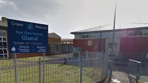 Google Google representation  of the entranceway  to Ysgol Gyfun Gymraeg Glantaf successful  Cardiff, showing fencing, roadworthy  and schoolhouse  buildings, arsenic  good   arsenic  the entranceway  sign