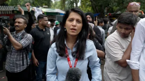 Woman stands amidst a crowd in India