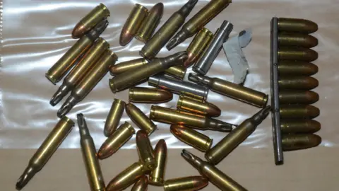PSNI A close-up photo of a small selection of ammunition. The bullets are lying on a flat surface which is partially covered by clear plastic