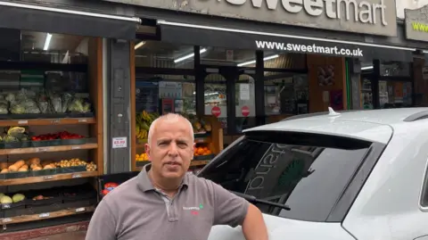 BBC Rashid Majothi stands in front of his shop Bristol Sweet Mart 
