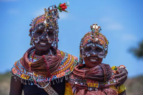 GERALD ANDERSON / GETTY IMAGES Two women from the Rendille community stand side-by-side, wearing brightly beaded jewellery and headdresses. 