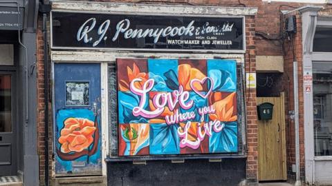A shop front with a mural
