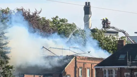 A large building on fire with no roof 