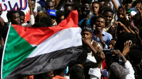 Reuters People at rally in Khartoum with Sudanese flag