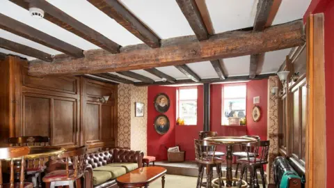 Historic England handout The interior of the Angel Inn which dates back to the 16th Century showing a leather sofa and poseur tables and high stools.