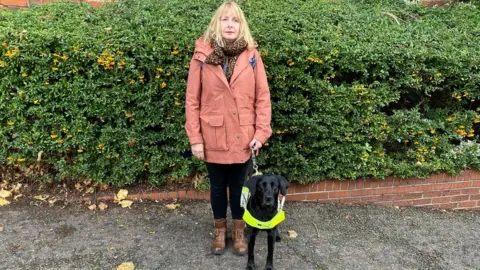 Johnnie Wright/BBC Carolyn Allum with guide dog Lea