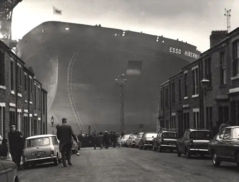 Newcastle City Council Photo of huge ship, Esso Hibernia at the end of street showing houses, cars and people