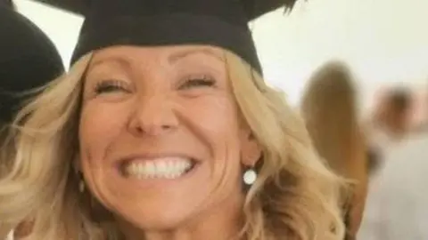 Claire Chick smiling at the camera. She has curled blonde hair and is wearing a mortarboard. 