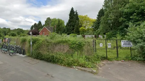 The site of the old Newbridge service station, which is now overgrown and gated.