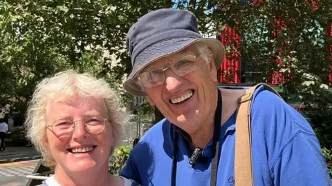 Cathy and Alan next to a giraffe statue