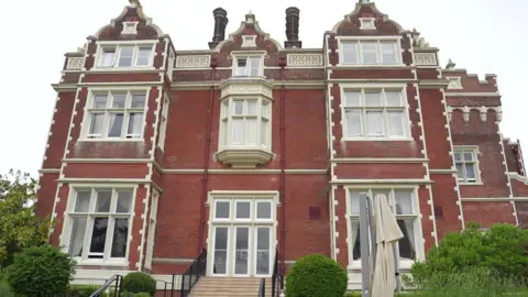 Richard Knights/BBC A red brick hotel with large window. It is an ornate 
