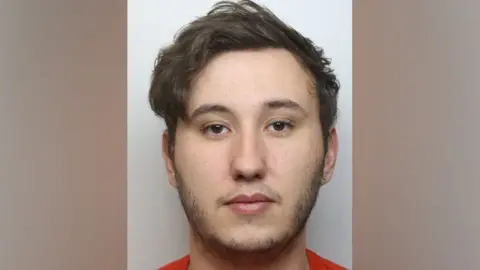 Northamptonshire Police Kay in an orange top facing the camera 