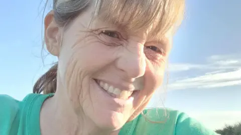 Peter Burge Allison Randlesome - a woman with a green T-shirt and grey/brown hair