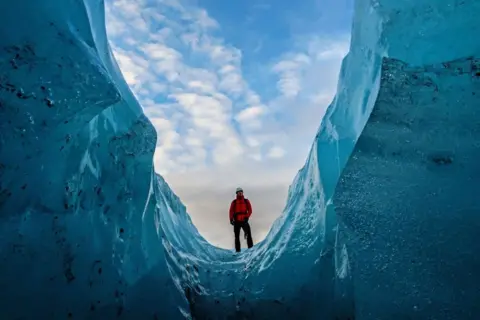 Craig Hannah A man inside a glacier