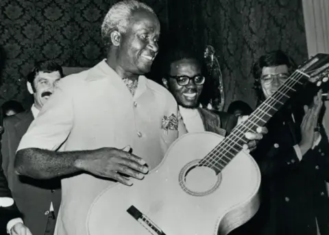 Alamy Zambia's President Kaunda playing the guitar on a visit to Portugal in 1975