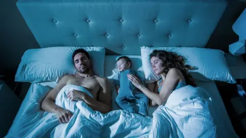 Getty Images Parents sharing a bed with their baby