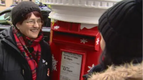 A woman listening to the post-box