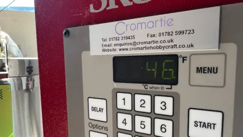 A screen on a machine reading a temperature of 46C