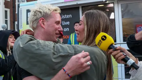 Getty Images Jamie Laing hugs with wife Sophie Habboo during day three of his 2025 Comic Relief challenge at Loughborough University on March 19, 2025 in Loughborough, England. Sophie is wearing a khaki coloured jacket and has her arms wrapped around Jamie, with Jamie visibly emotional 