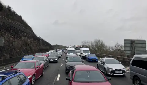 Cars queued up on the M5 motorway. They are facing towards the camera