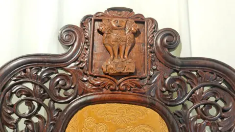 Cherylann Mollan The chair features an Ashoka emblem made of wood that's of a different colour. Gandhi says that it's possible the chair was later repurposed for use in an Indian government office.